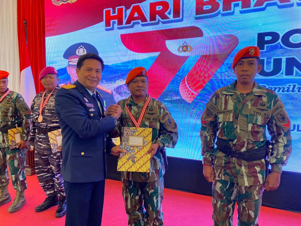Komandan Lanud El Tari Kupang, Marsma TNI Aldrin P Mongan memberikan piagam penghargaan kepada juara lomba menembak dalam rangka HUT bhayangkara ke-77.